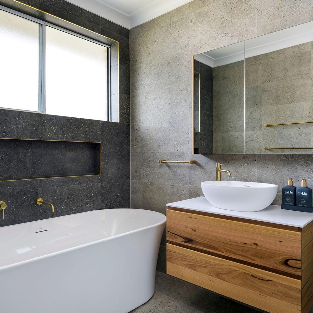 An industrial bathroom showcasing a freestanding egg-shaped bathtub and a warm-toned wood vanity.