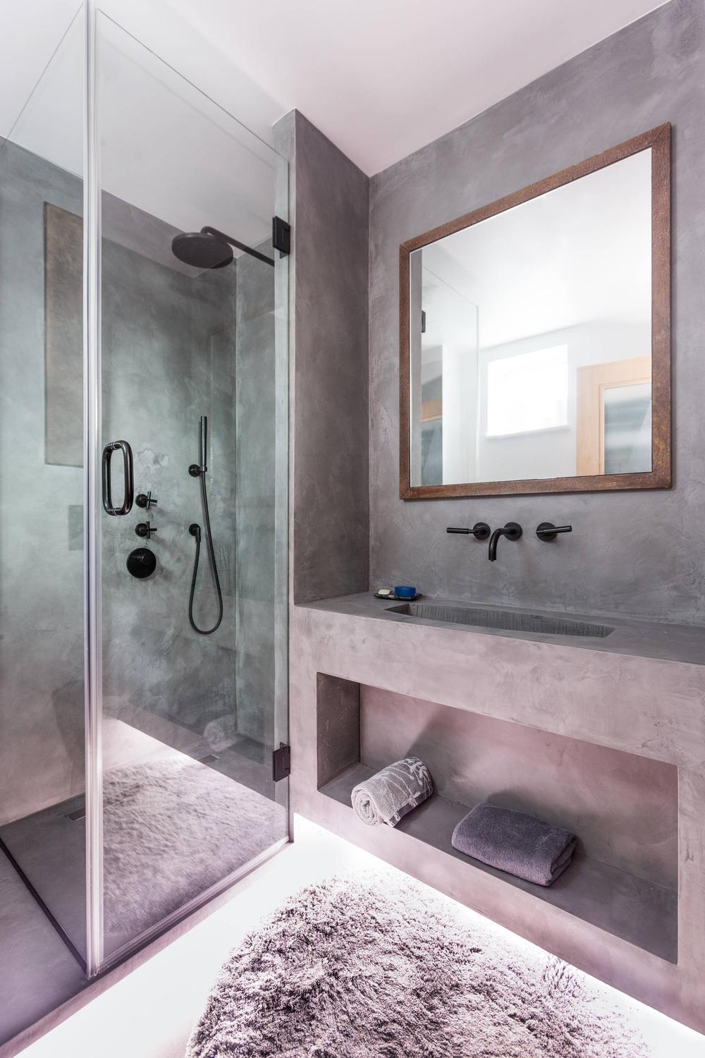 Baño industrial en tonos oscuros y elementos lujosos