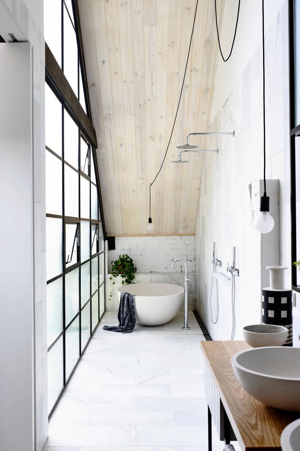 Baño industrial contemporáneo bajo un techo escalonado