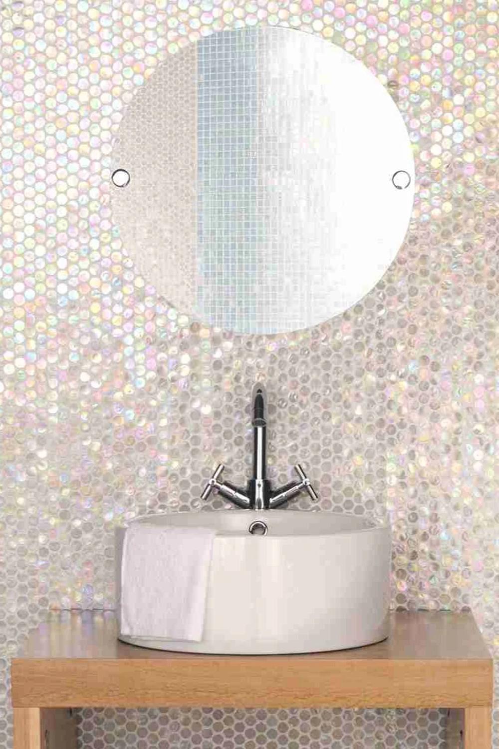Pared de azulejos iridiscentes en un elegante baño.