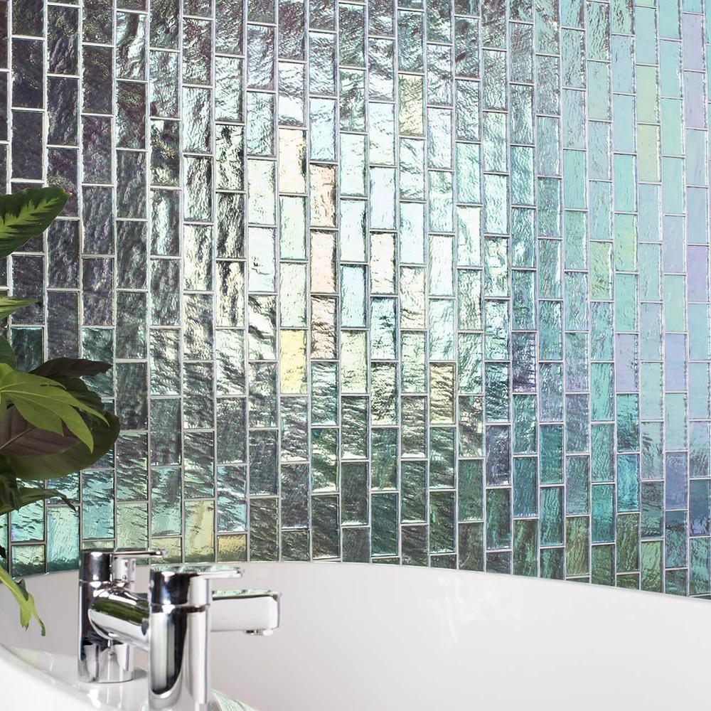 Pared de azulejos iridiscentes en un elegante baño.