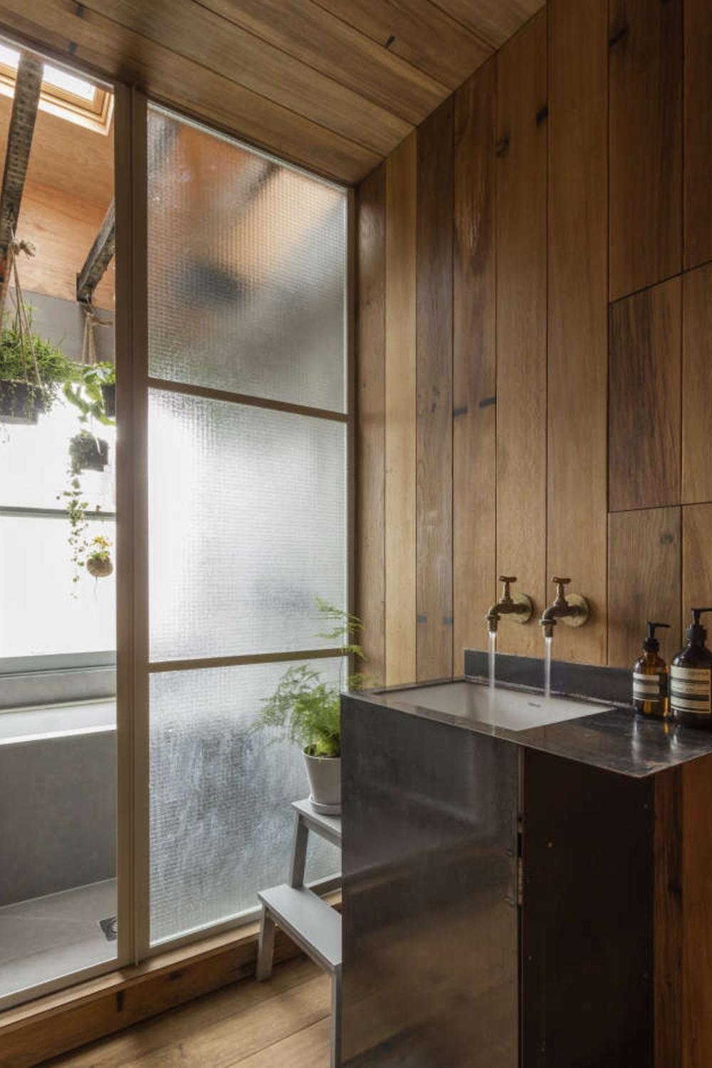 Baño japonés con separación de cristal y encanto natural