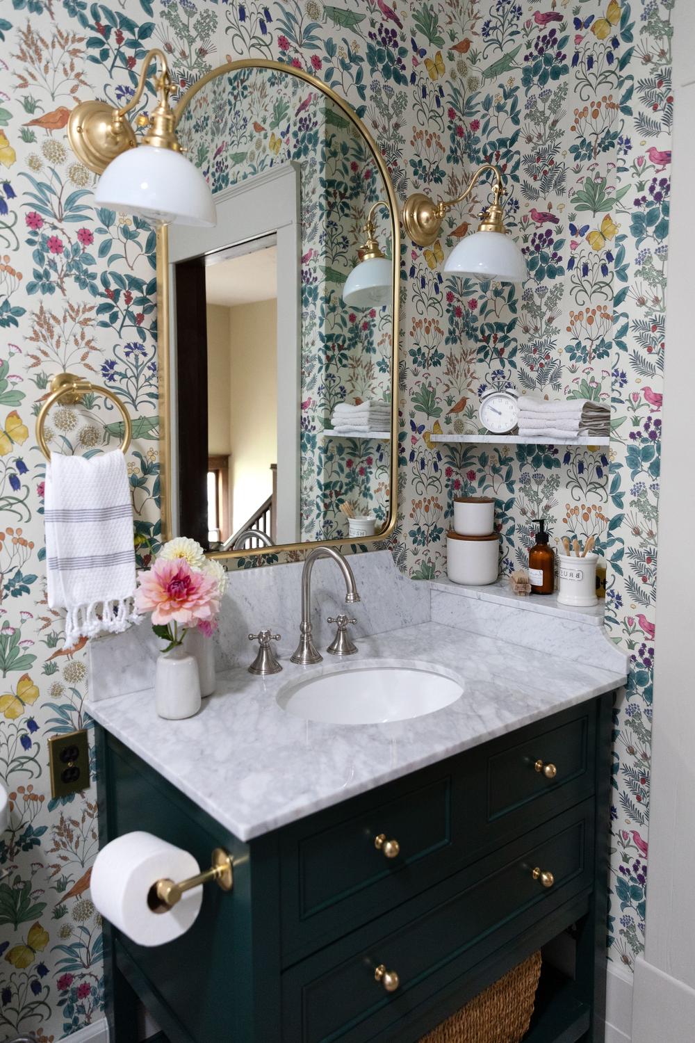 A sophisticated kids' bathroom featuring a dark green vanity and light touches.