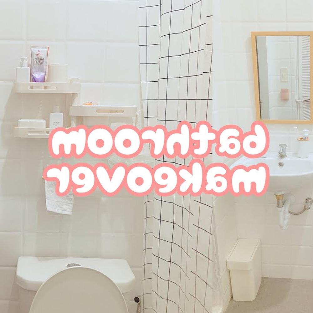 A small, modern Korean bathroom characterized by clean white tiles and a highly functional layout, featuring a wall-mounted sink and charming storage options.