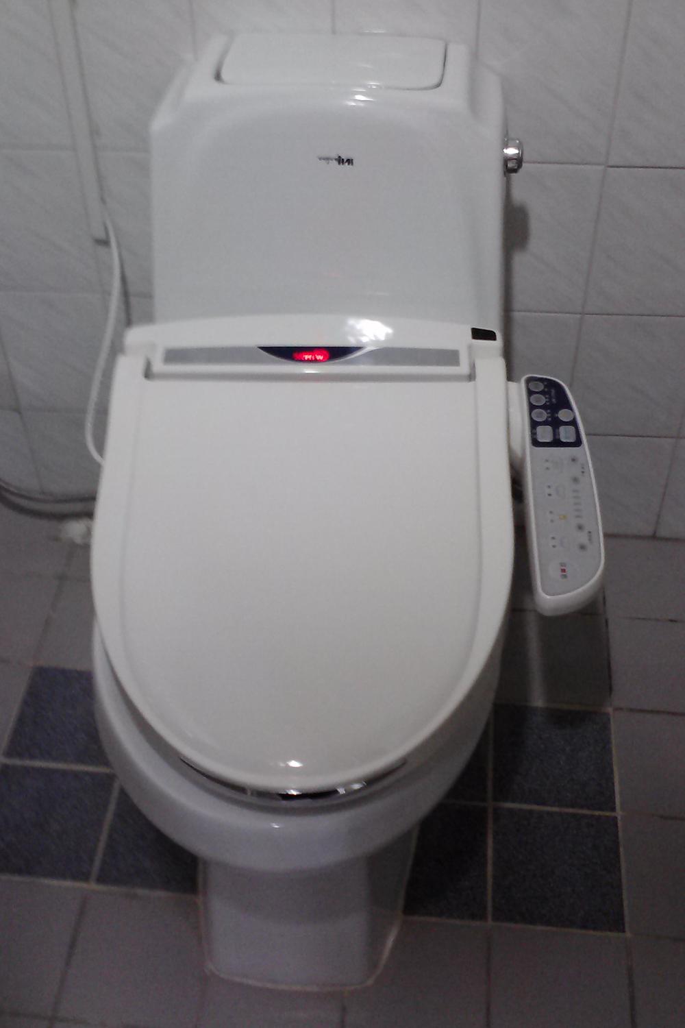 A modern Korean bathroom showcasing a high-tech bidet toilet with a sleek design and advanced features.