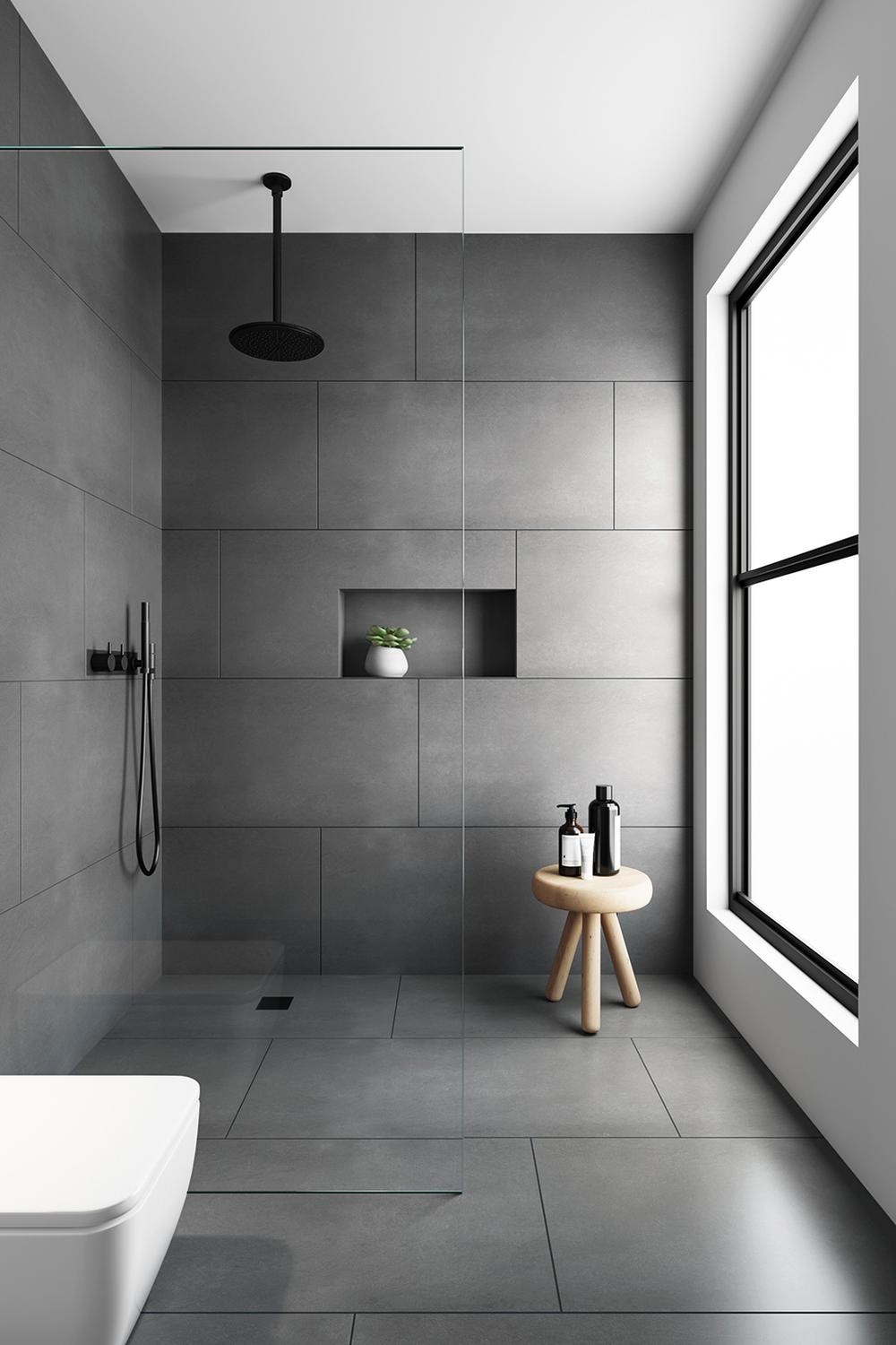Modern bathroom with large gray tiles, sleek fixtures, and natural lighting