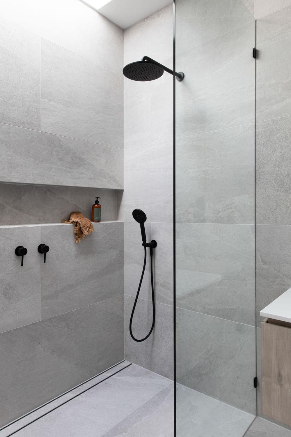 Modern shower design with large format tiles in a minimalist style