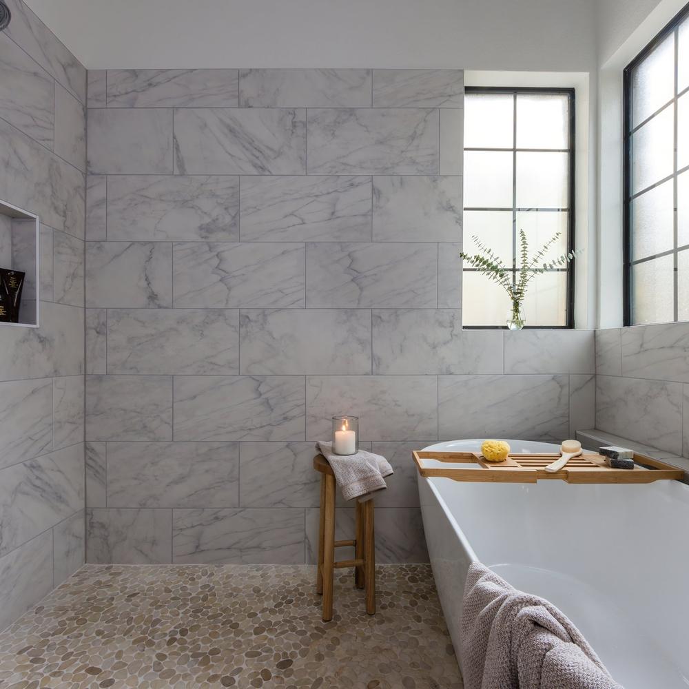 Contemporary bathroom featuring marble-like large format tiles and a freestanding tub