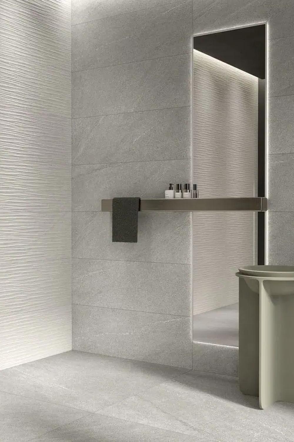 Baño moderno con iluminación cálida y baldosas de caliza