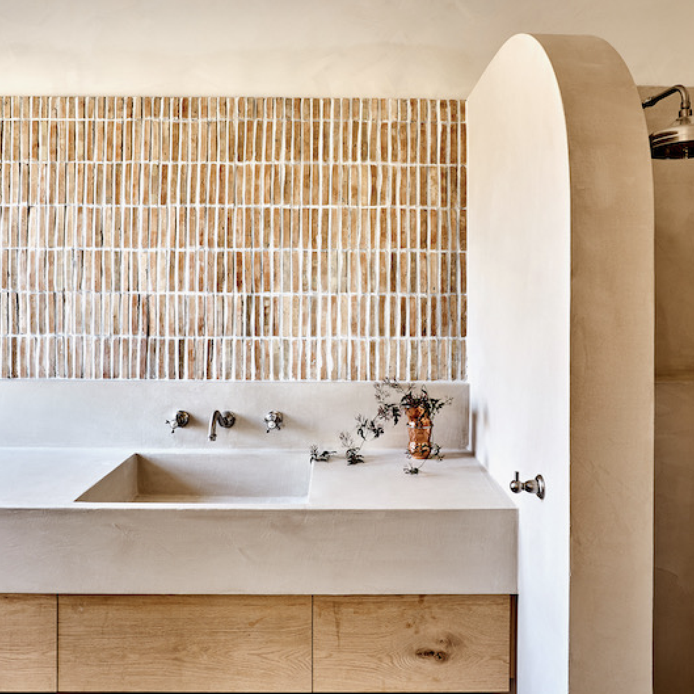 A sleek bathroom featuring a minimalistic floating vanity with limewash finishes.
