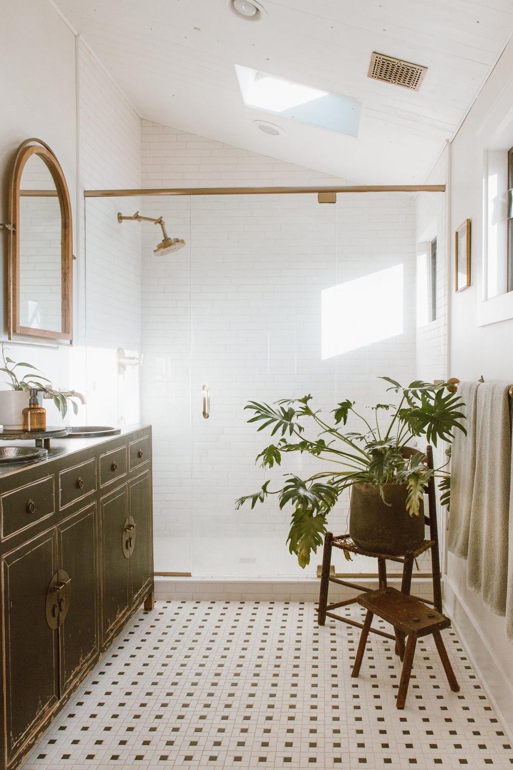 An inviting bathroom showcasing a dark green vanity paired with light limewash walls.