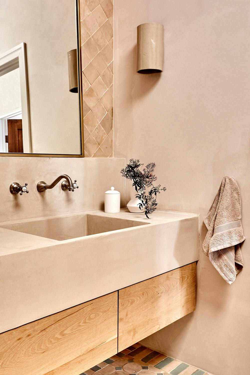 A minimalist bathroom showcasing limewash finishes and earthy accents.