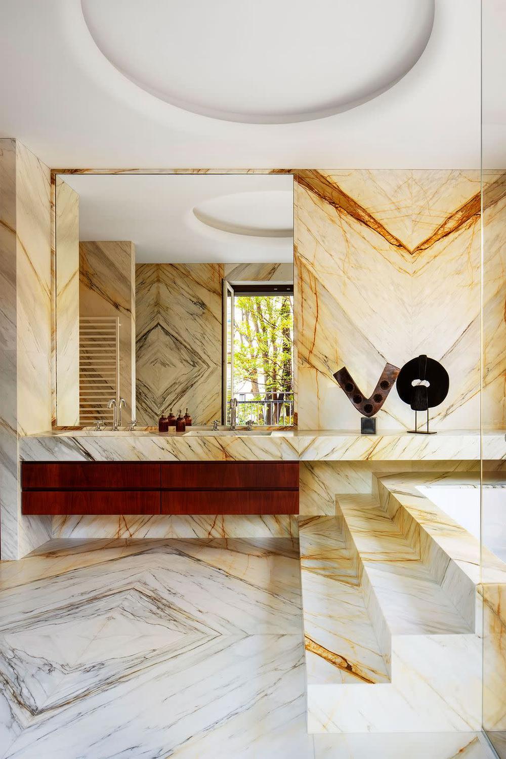 Baño lujoso maximalista con mármol y detalles dorados