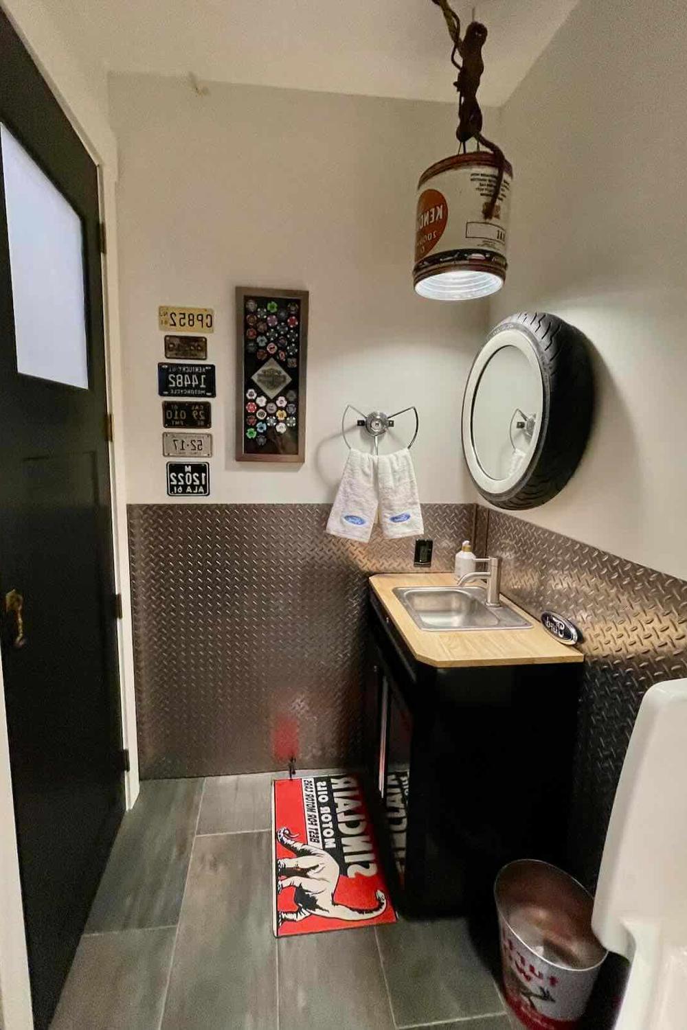 Baño industrial con un toque juguetón, azulejos de metal, y detalles vintage