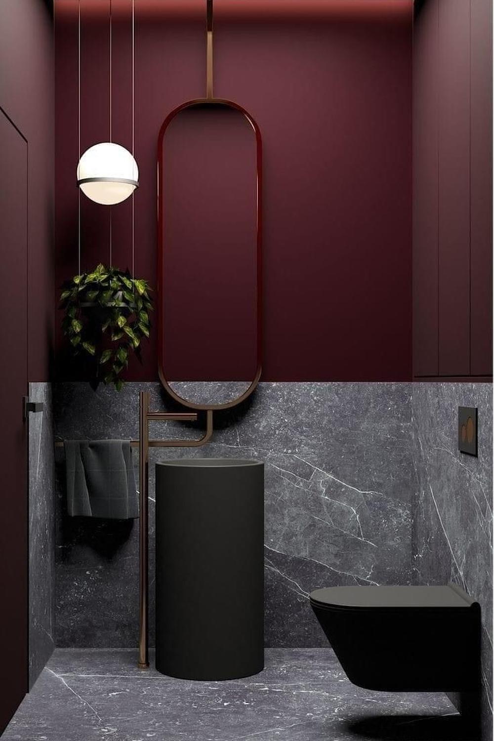 Modern bathroom with deep maroon walls and a striking pendant light enhancing the elegant atmosphere.