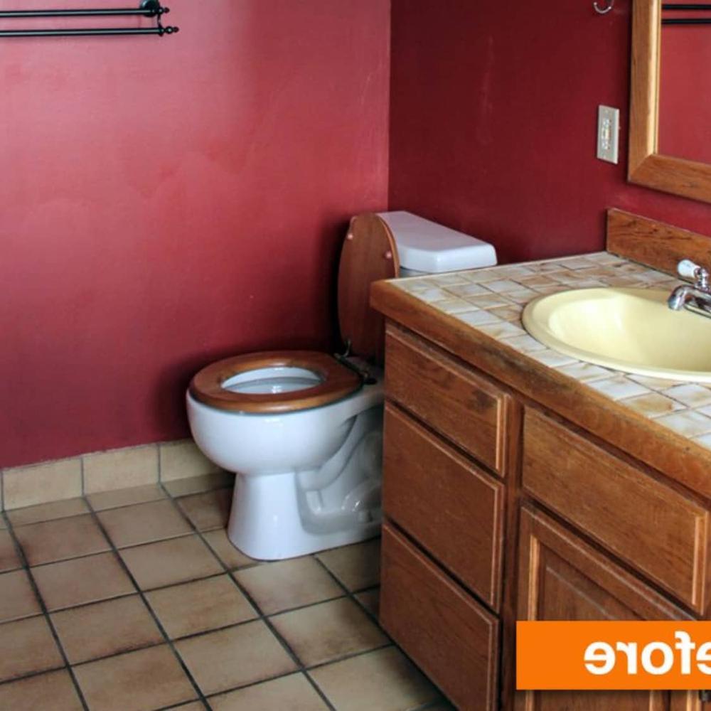 Warm compact bathroom with maroon walls and wooden accents, creating a cozy atmosphere.