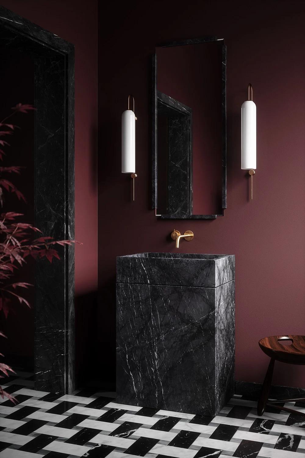 Stylish bathroom featuring a black marble sink and warm maroon walls, surrounded by elegant lighting.