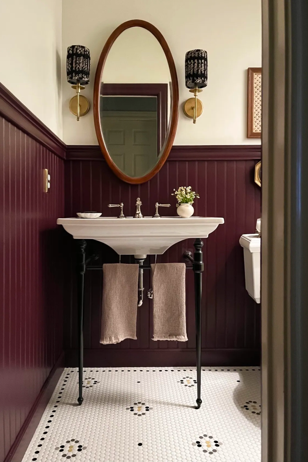Chic maroon bathroom design featuring a vintage sink and elegant decor elements creating a sophisticated space.
