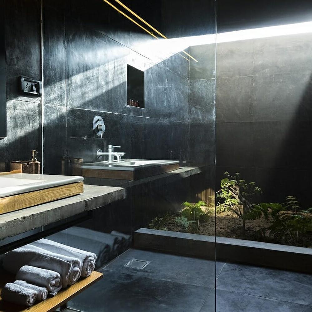 A minimalist masculine bathroom with a blend of black and gray tones.