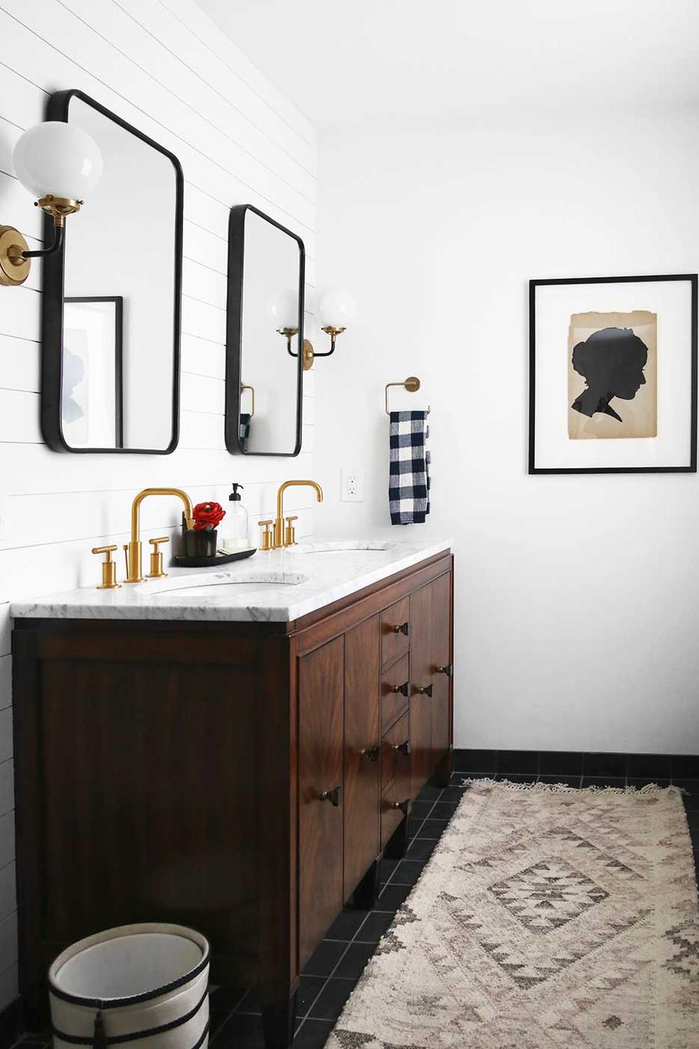 A luxurious masculine bathroom featuring dark wood, marble, and elegant fixtures.