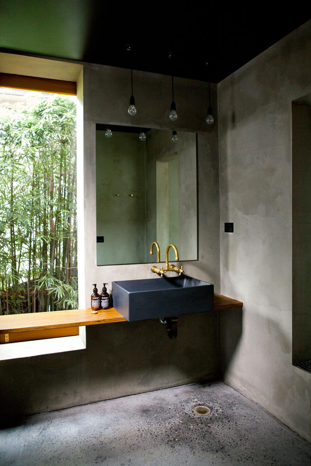 An industrial-style masculine bathroom featuring concrete walls and a minimalist approach.
