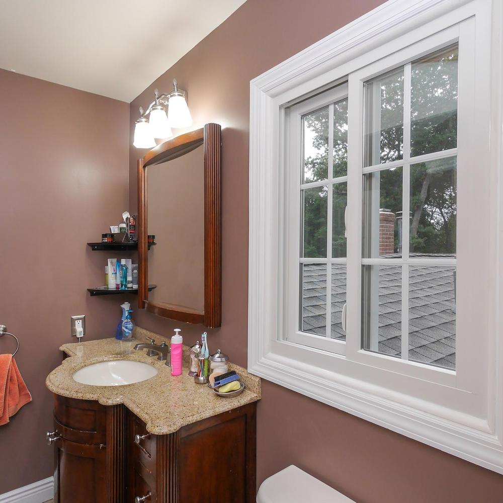 Vintage-inspired compact mauve bathroom with elegant dark wood cabinetry.