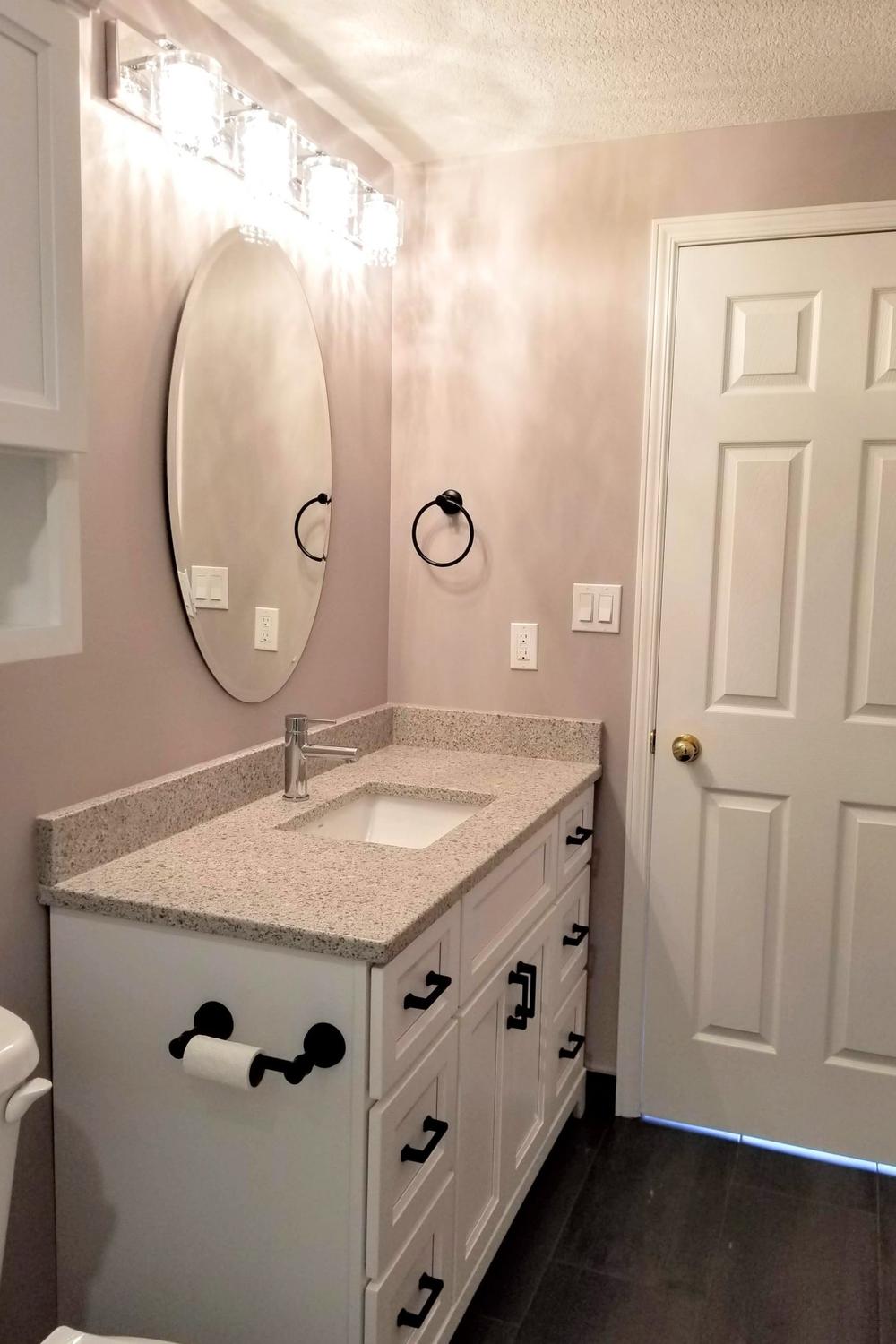 Modern minimalist bathroom with a classic mauve wall and sleek fixtures.