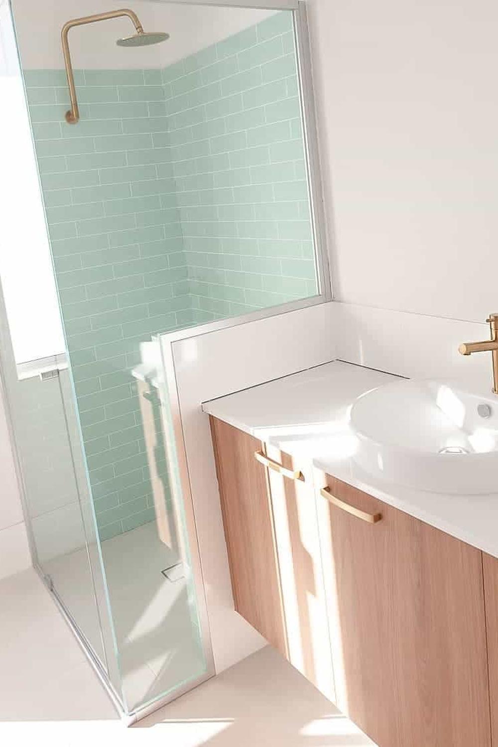 Stylish bathroom enclosure showcasing stacked mint green shower tiles.