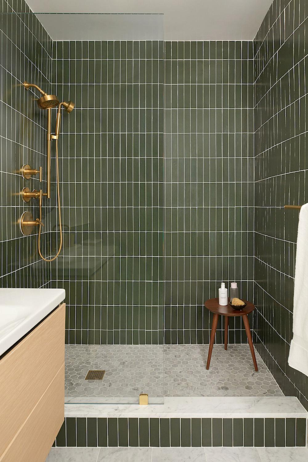 Contemporary bathroom showcasing dark green tiles alongside bold geometric patterns.