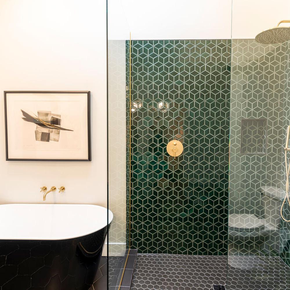 Stylish contemporary bathroom featuring mint green tiles and gold fixtures.