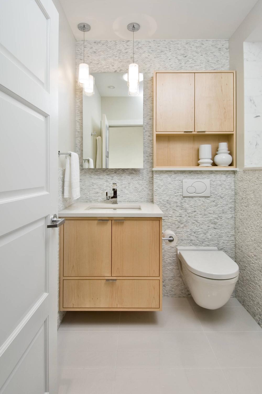 Clean modern bathroom with light wood vanity and white accents