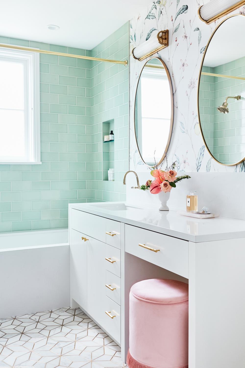 Stylish bathroom blending mint green tiles with floral wallpaper