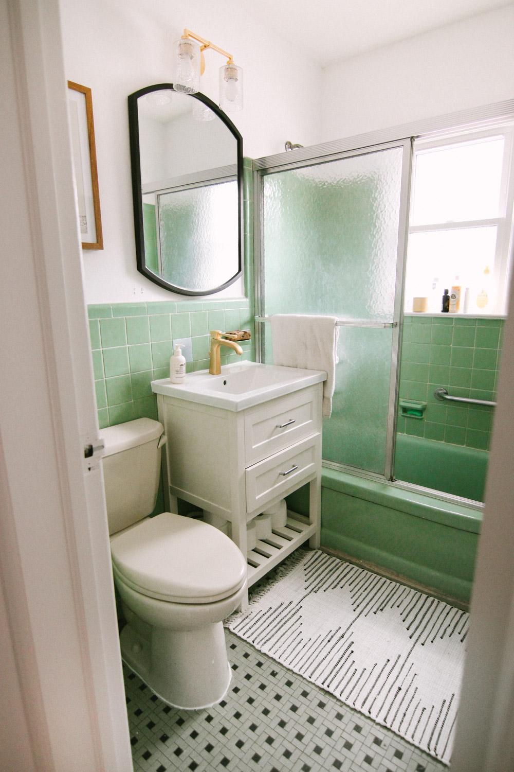 Mint green and white bathroom with glass sliding shower door