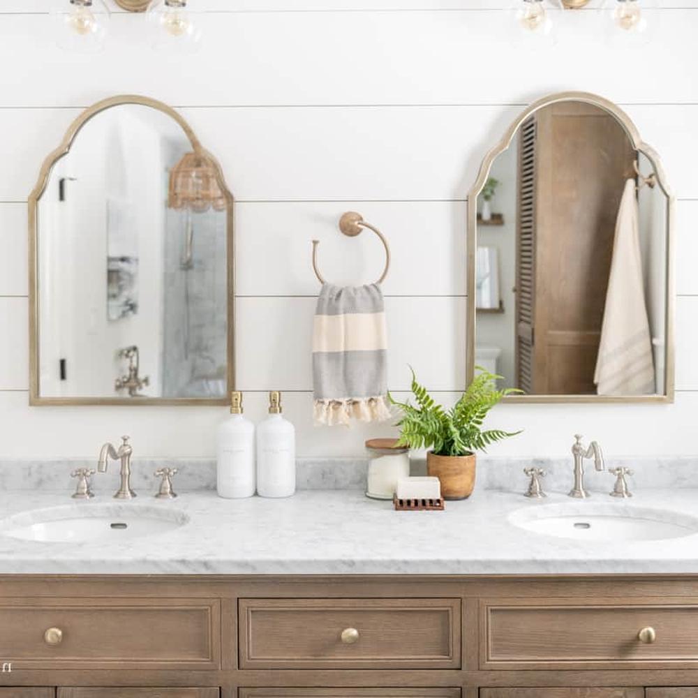 Baño acogedor con metales mezclados y madera natural en acabados cálidos.