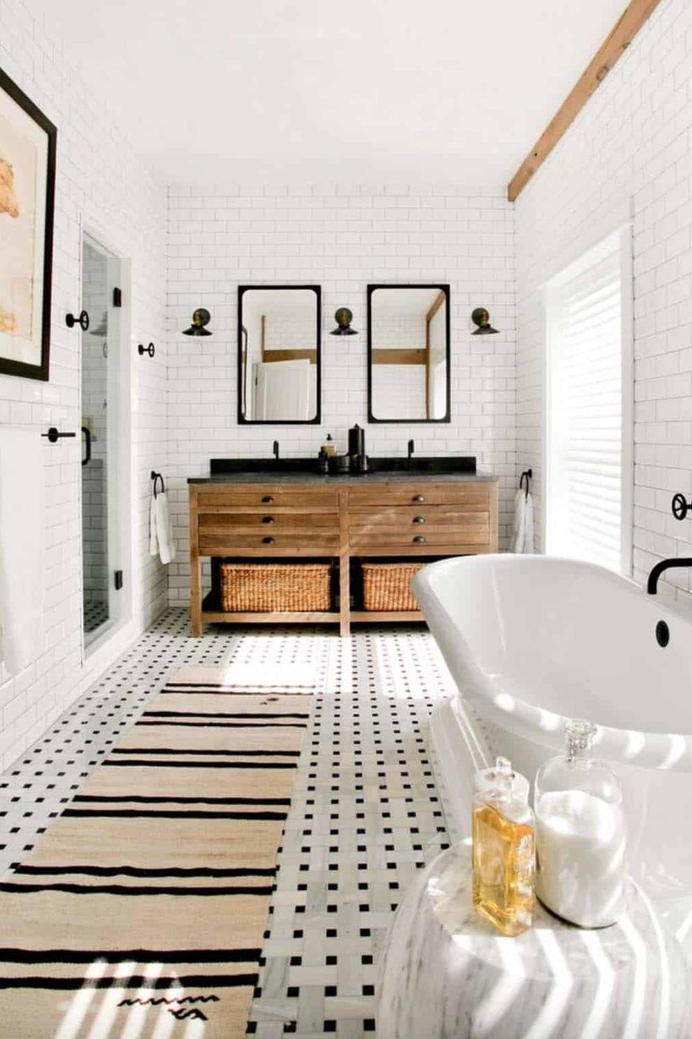 Modern farmhouse bathroom featuring bright white subway tiles and a dark tile floor.