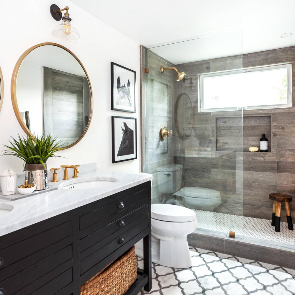 Modern farmhouse bathroom showcasing white marble countertops and a sleek black vanity.