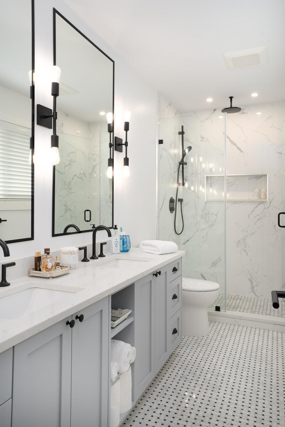 Stylish modern farmhouse bathroom with soft gray cabinetry and modern fixtures.