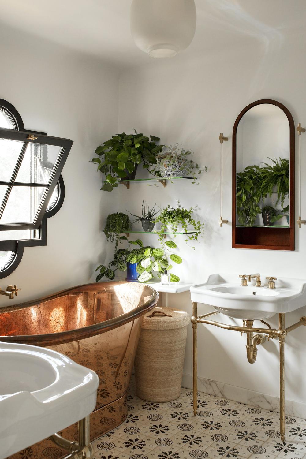 Charming farmhouse bathroom with a copper bathtub and patterned tiles.