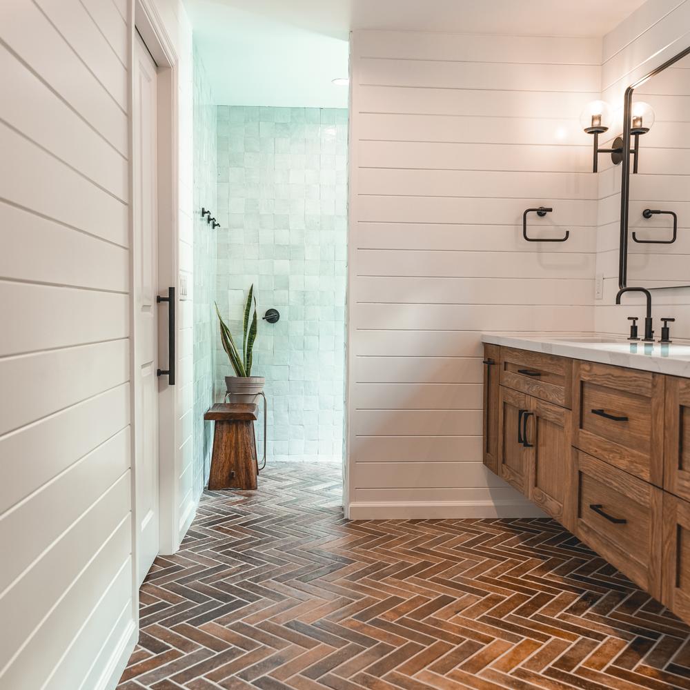 Cozy bathroom with white shiplap walls and warm accents.