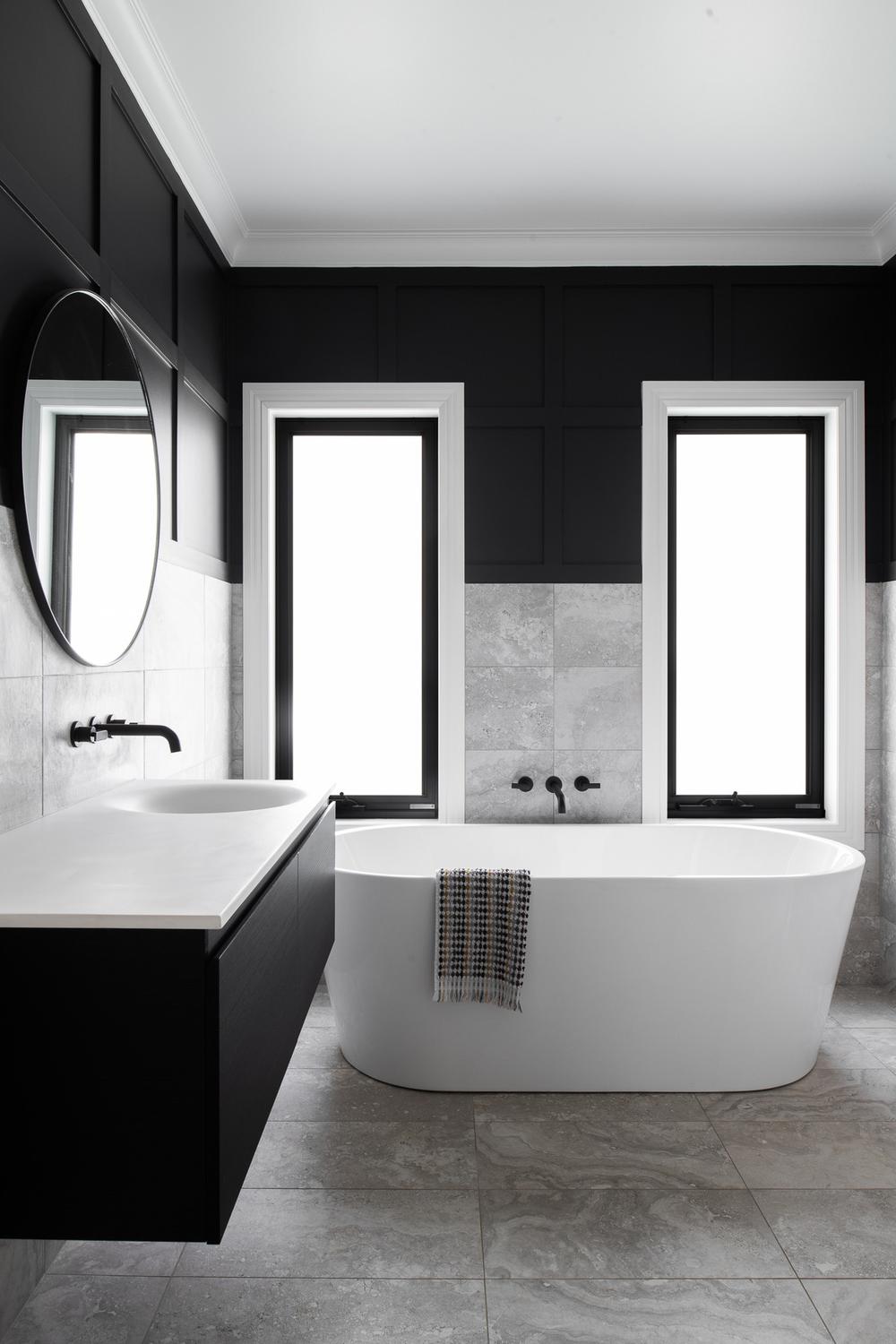 Chic modern farmhouse bathroom emphasizing black and white features.