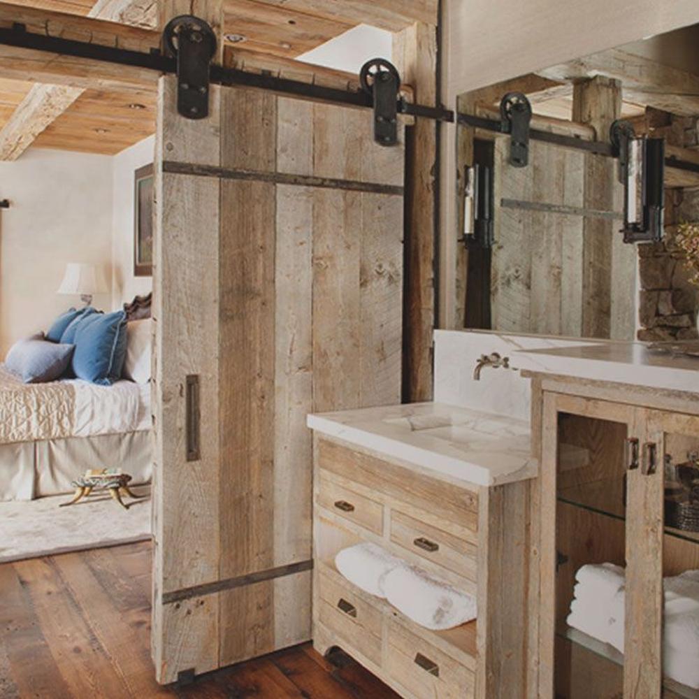 Modern farmhouse bathroom with sliding barn door and rustic accents.