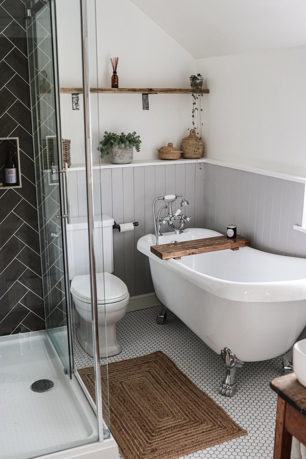 A modern cottage bathroom with a freestanding tub, patterned flooring, and natural textures.