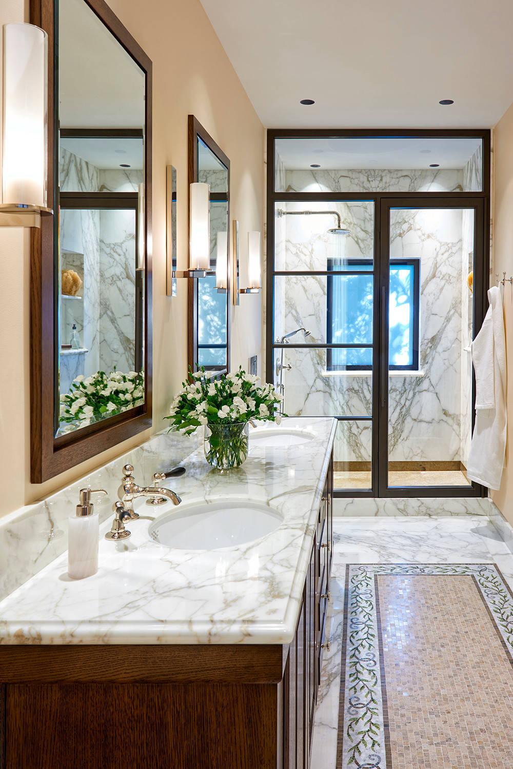 Luxurious modern Mediterranean bathroom with marble features and rich wood cabinets.