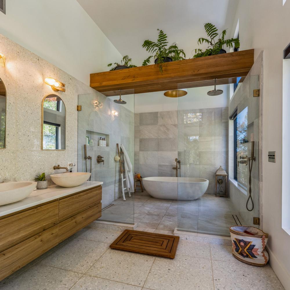 Baño moderno con doble lavabo y apertura de ducha de cristal