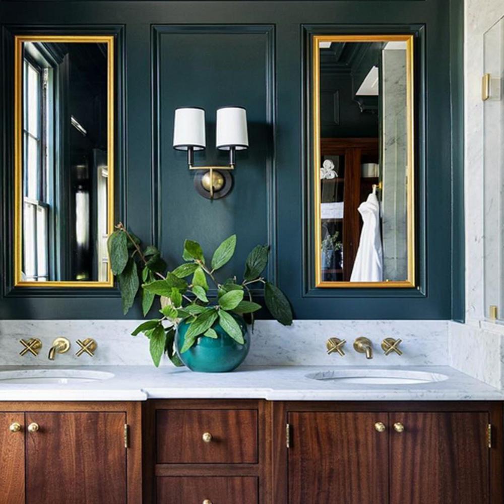 Stylish moody bathroom featuring deep green walls and elegant gold accents
