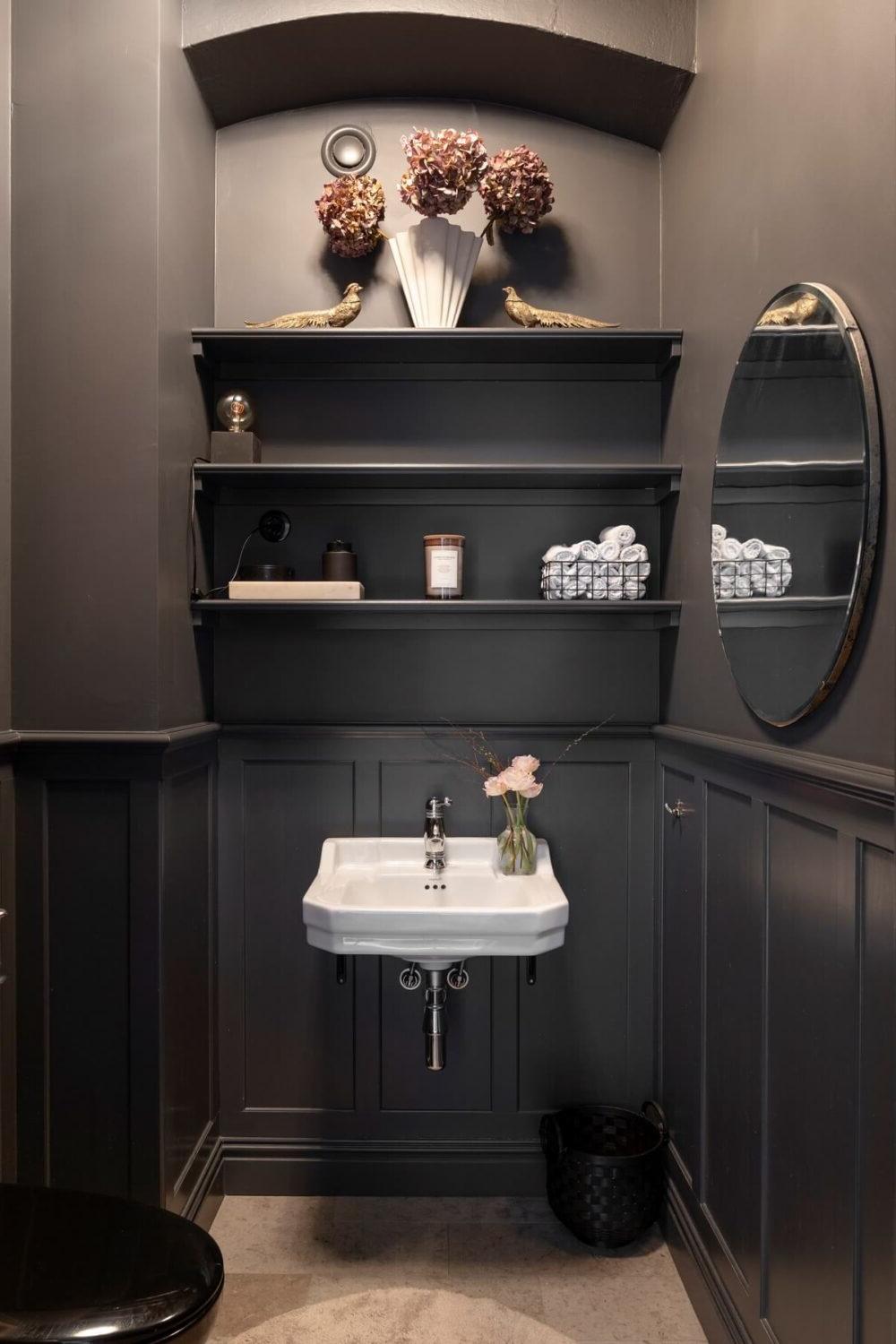 Moody bathroom with deep gray walls and vintage white sink