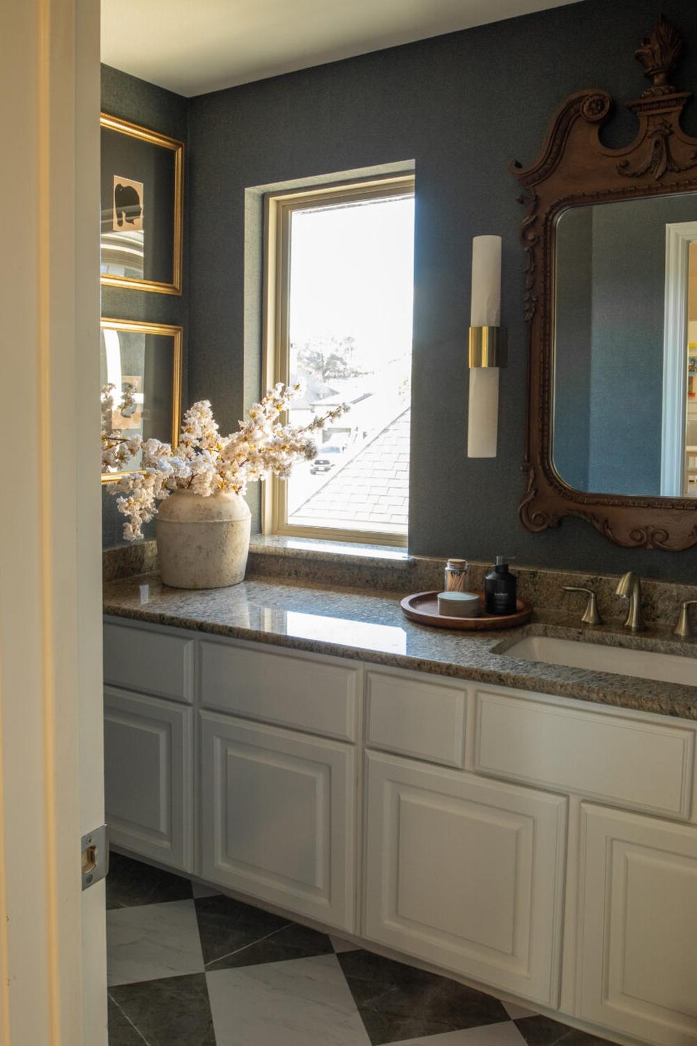 Stylish moody bathroom with ornate mirrors and natural light