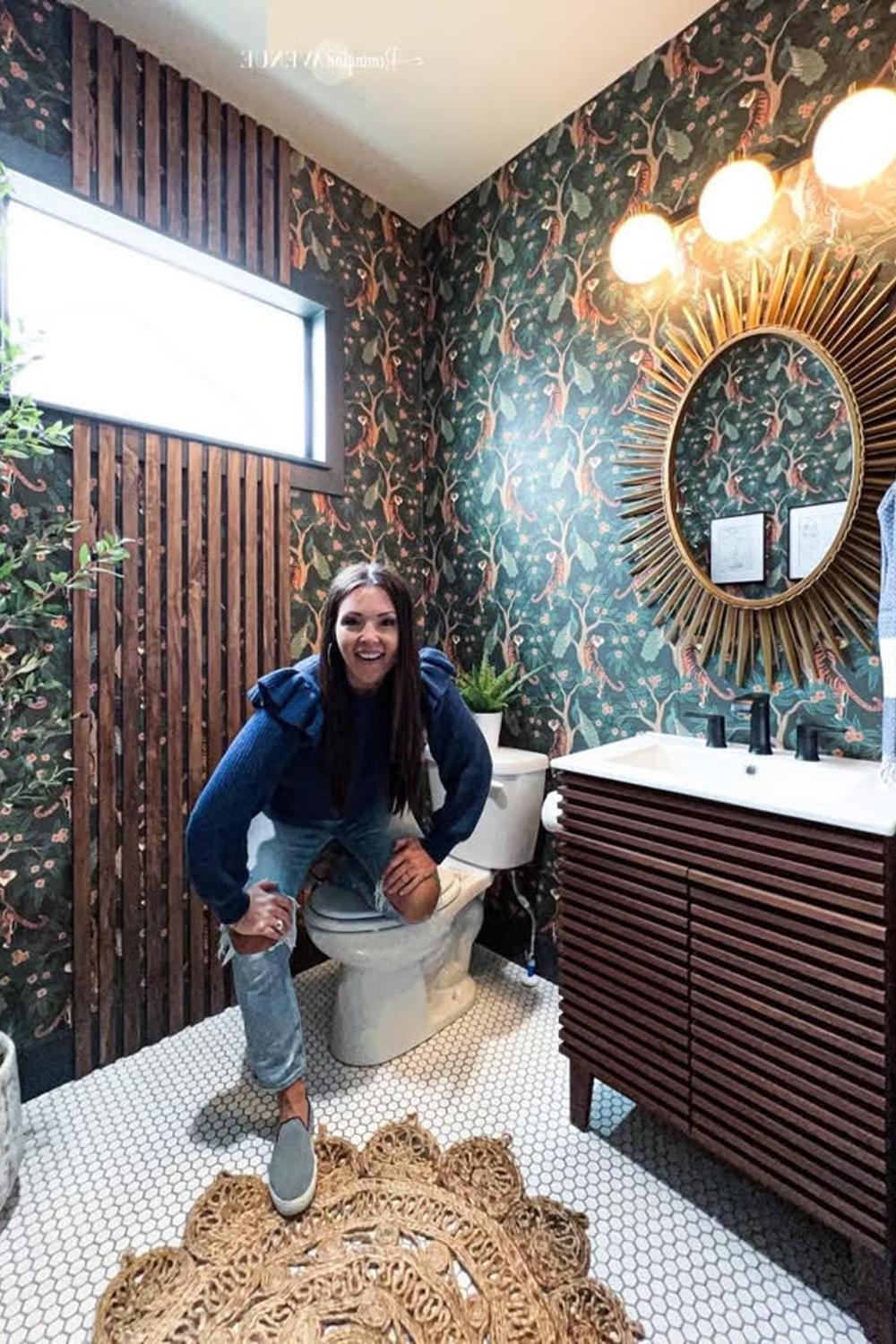 Baño elegante con papel pintado floral en tonos oscuros y azulejos hexagonales blancos