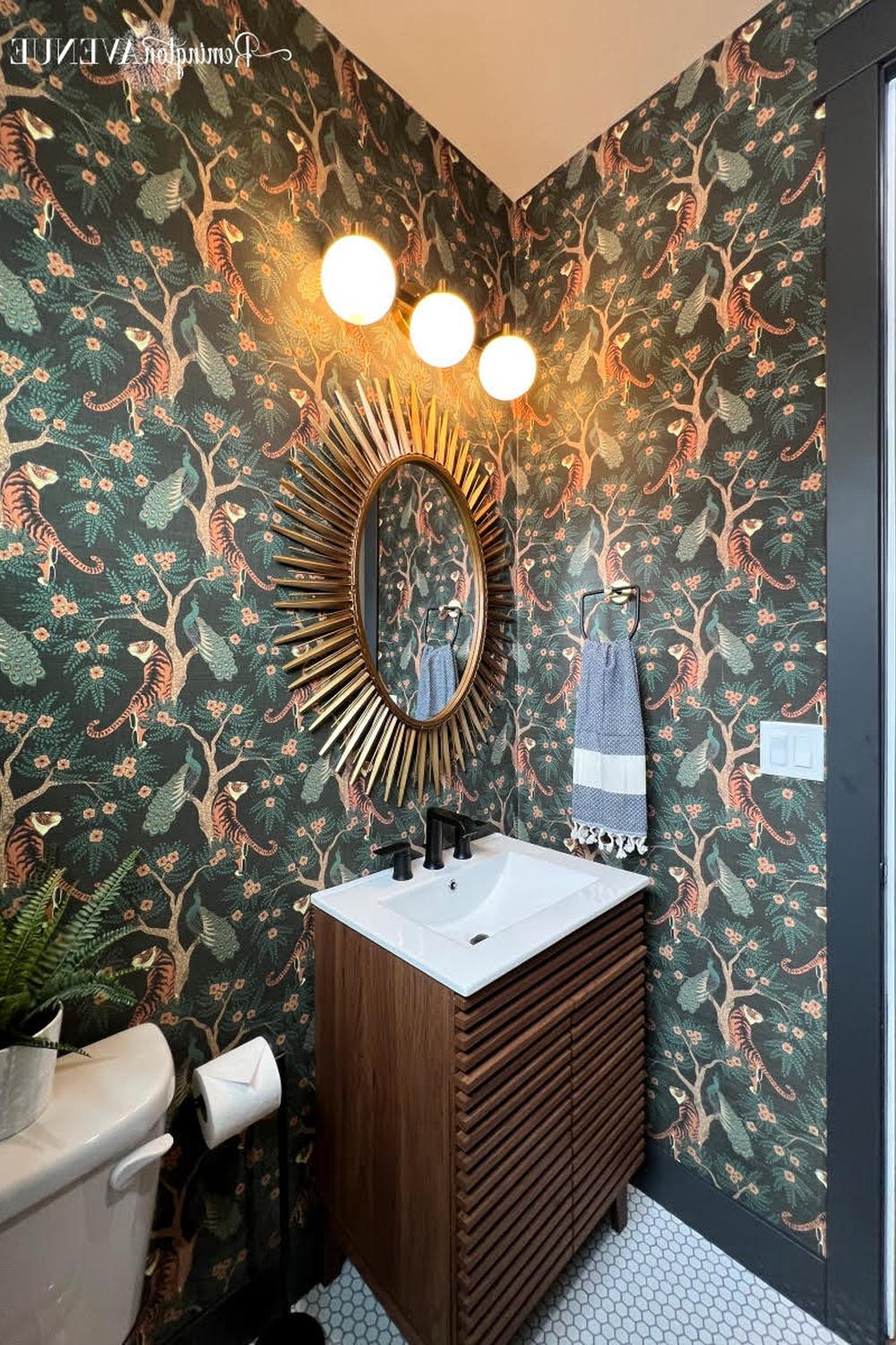 Baño con papel pintado que muestra tigres y vegetación sobre un fondo verde oscuro