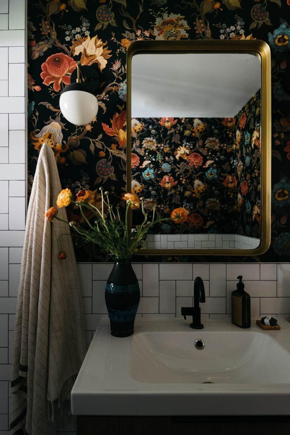 Baño contemporáneo con papel pintado oscuro adornado con flores vibrantes y lavabo moderno